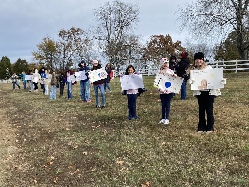 SES Students Line Road with Signs