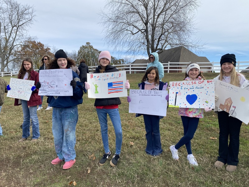 SES Students Line Road with Signs
