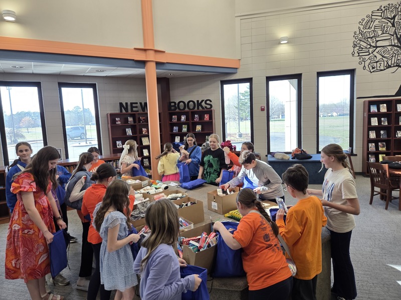 NMMS students stuffing backpacks