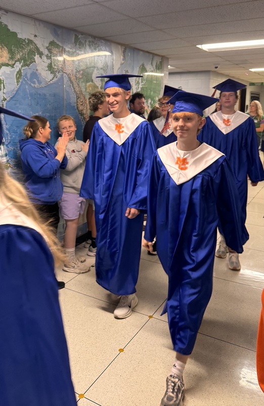 Seniors walking throug SES in cap and gown