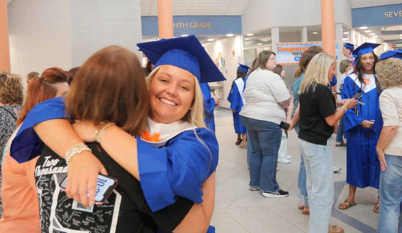 Senior hugging someone in NMMS lobby