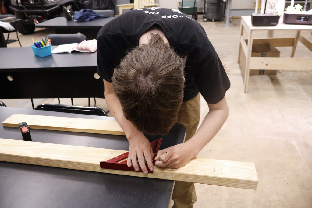 A student using an angled ruler to measure