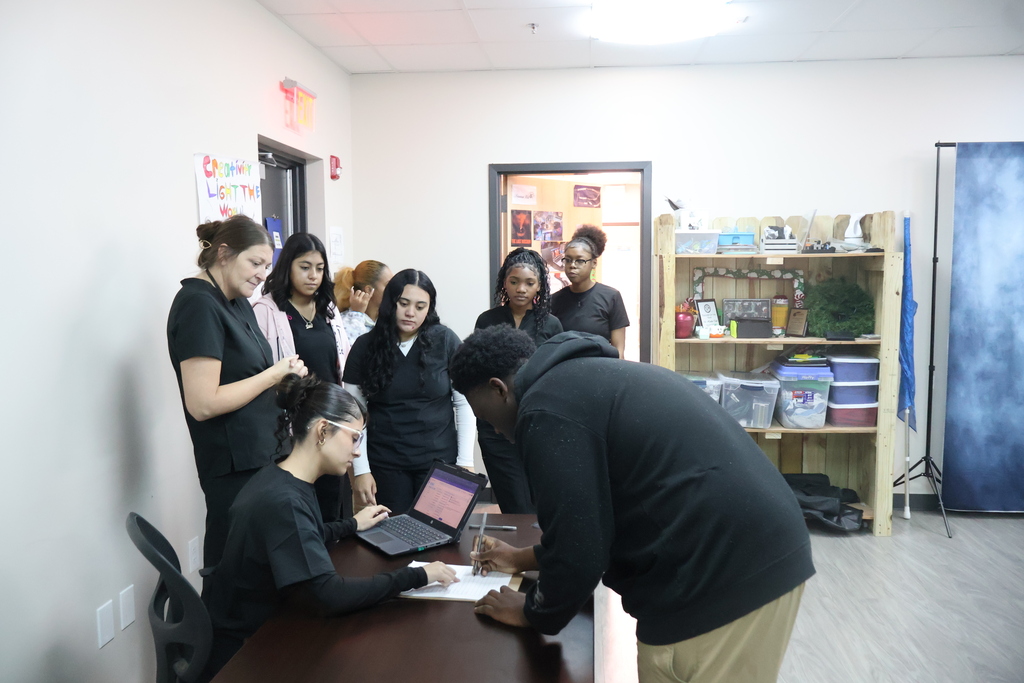 Health Science students assisting a patient at reception