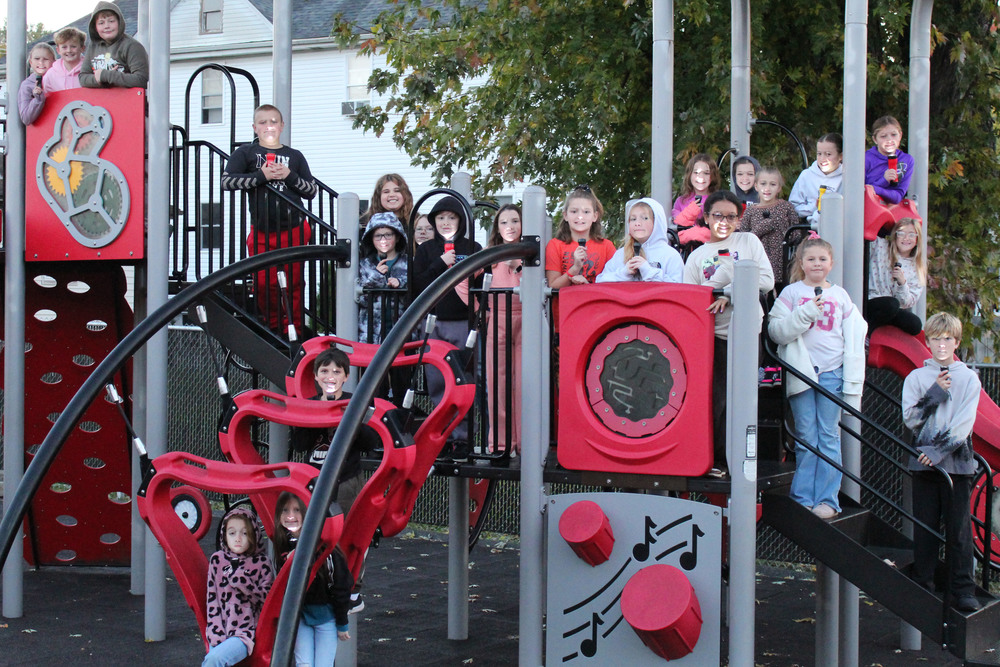 Students look at spiders on the school's playground.