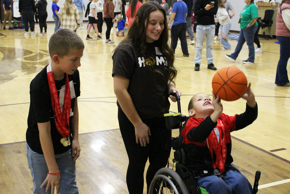 Student athletes and peer tutors play basketball.