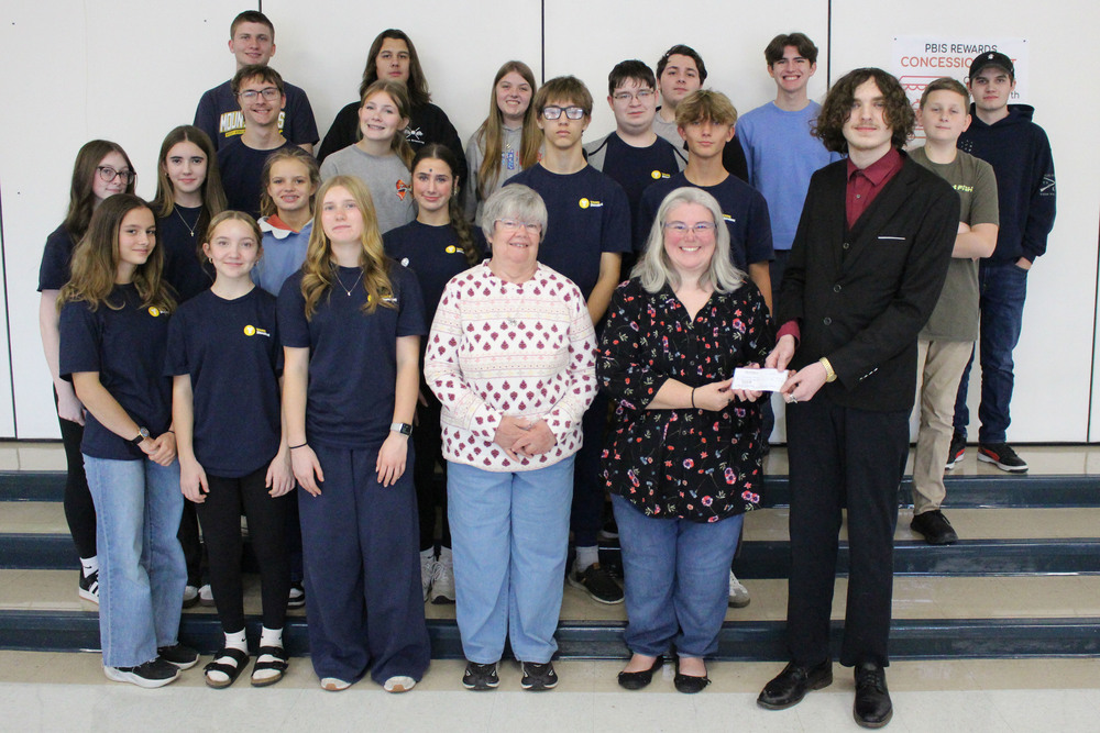 Students give a check to the Shepherd's Pantry, 