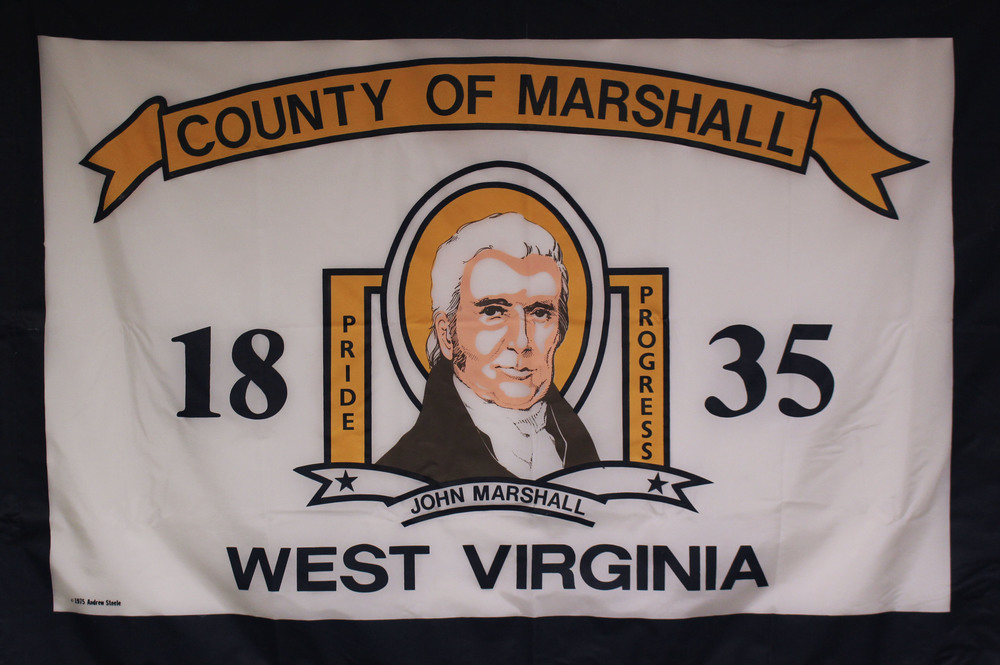 White Marshall County flag. County of Marshall is written in blue over top of a yellow ribbon. John Marshall is flanked by 1835 with Pride and Progress also on both sides of his portrait. . West Virginia is written in blue at the bottom of the flag.