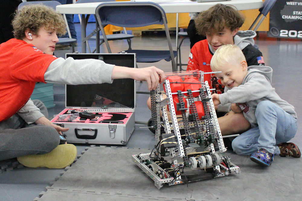 Sherrard Middle School 8th graders Josh Naome and Nathan Spangler are demonstrating, to TJ Klemm, the first prototype of their robot before their first competition of the 2025-2026 season for the game Push Back, which will be at John Marshall High School on Saturday, November 1st. Naome and Spangler are on Sherrard's VEX V5 Robotics team 26003S.