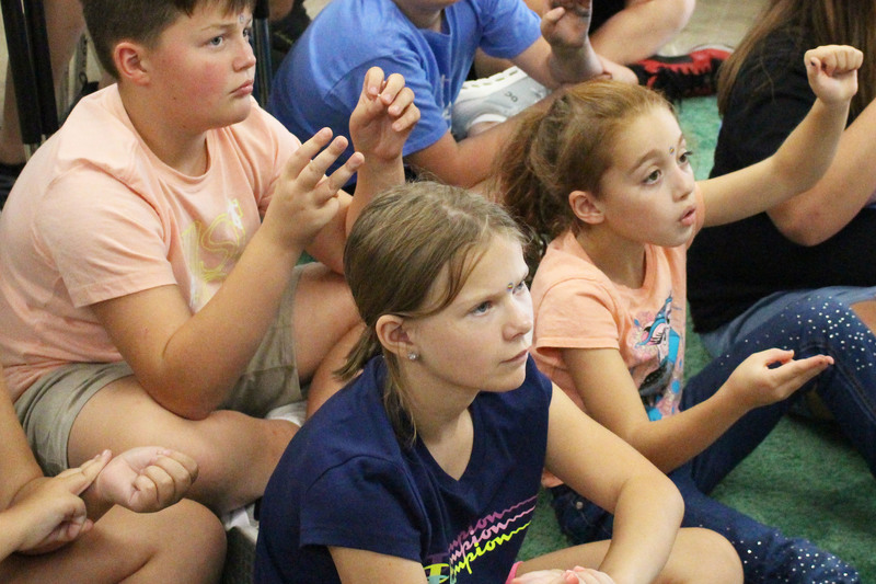 Kaylee During and Josilyn Fields (from left front row) and Garrett Simmons (back row) are pressing their thumbs gently on their wrist, three finger-widths above the crease. This can help with nervous feelings, motion sickness or an upset stomach.