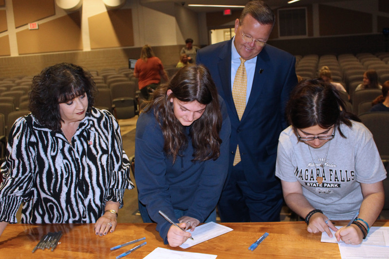 Students fill out a voter registration card.