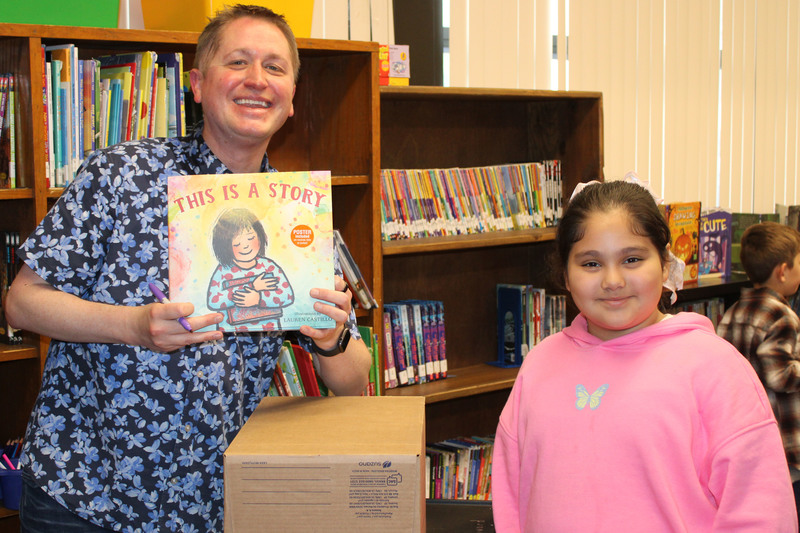 John Shu held a meet-and-greet with students in their classrooms. Shu is pictured with Central Elementary 4th grader Alma Castro Gamez. He is signing a copy of his book, This Is a Story, illustrated by Caldecott Honor artist Lauren Castillo.