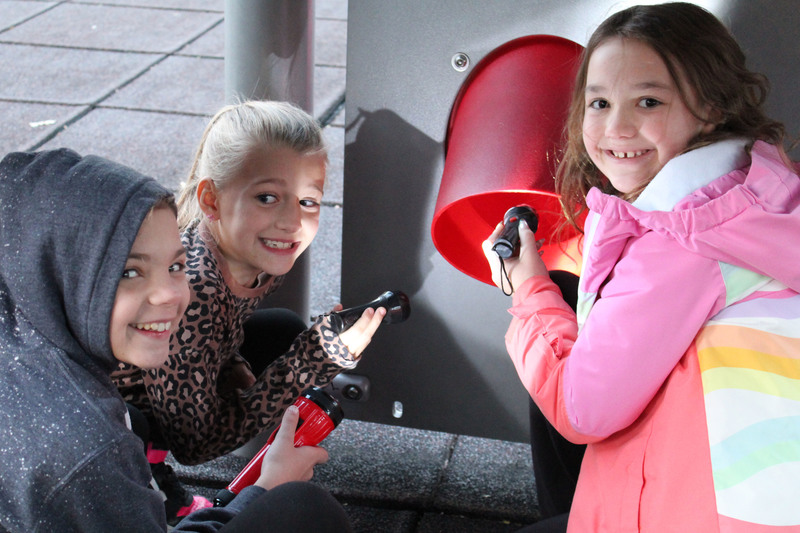 Students look at spiders on the school's playground.