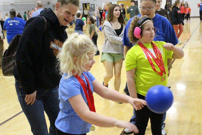 Student athletes and peer tutors play basketball.