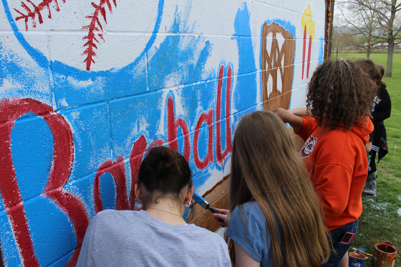 Middle school students paint a mural.