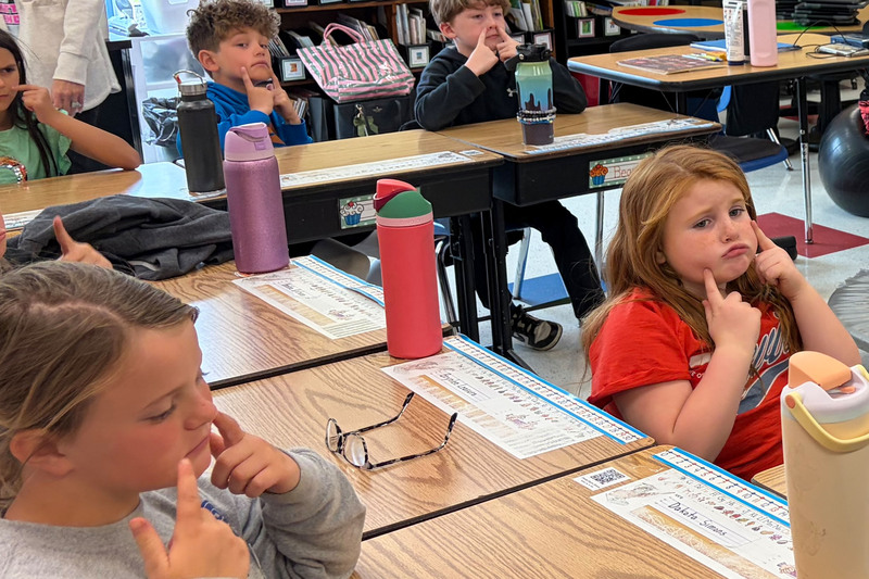 Students working at desks in a classroom.