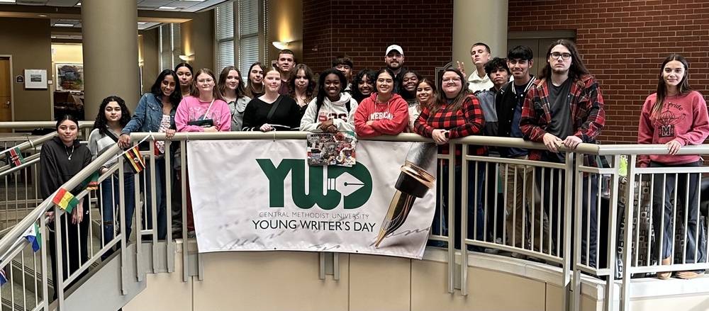 students taking photo around a writers day banner