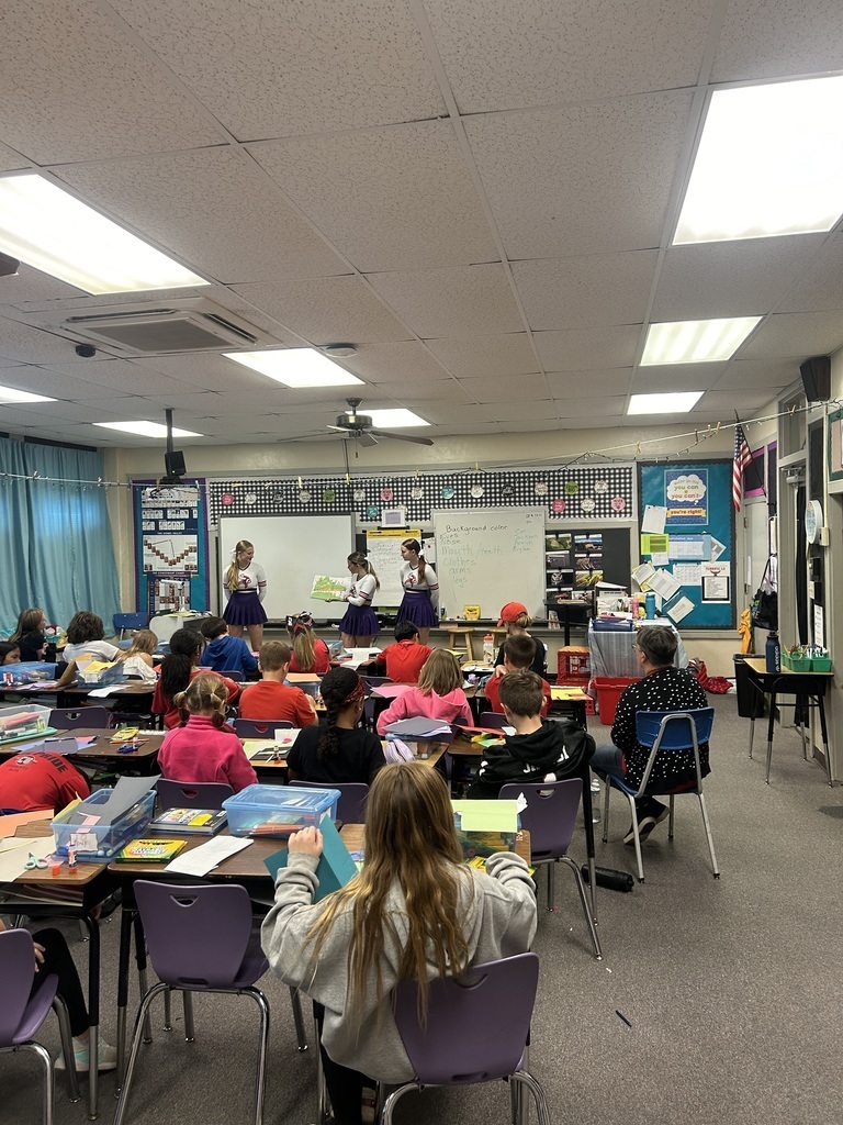 cheerleaders reading to students
