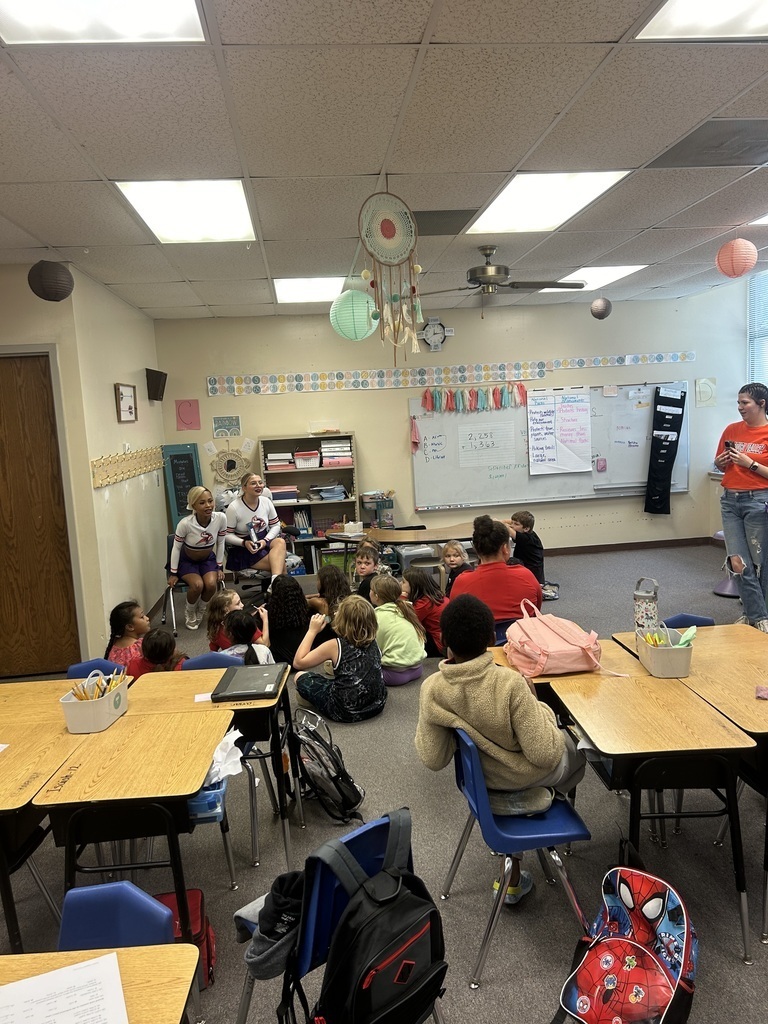 cheerleaders reading to students