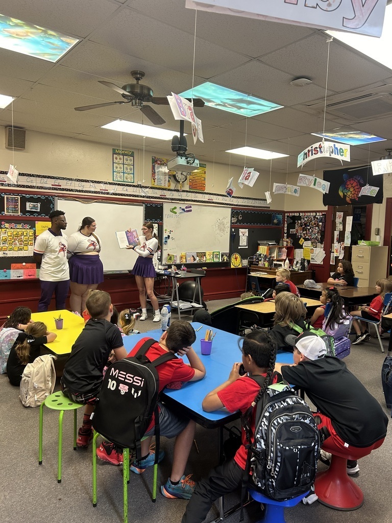 cheerleaders reading to students