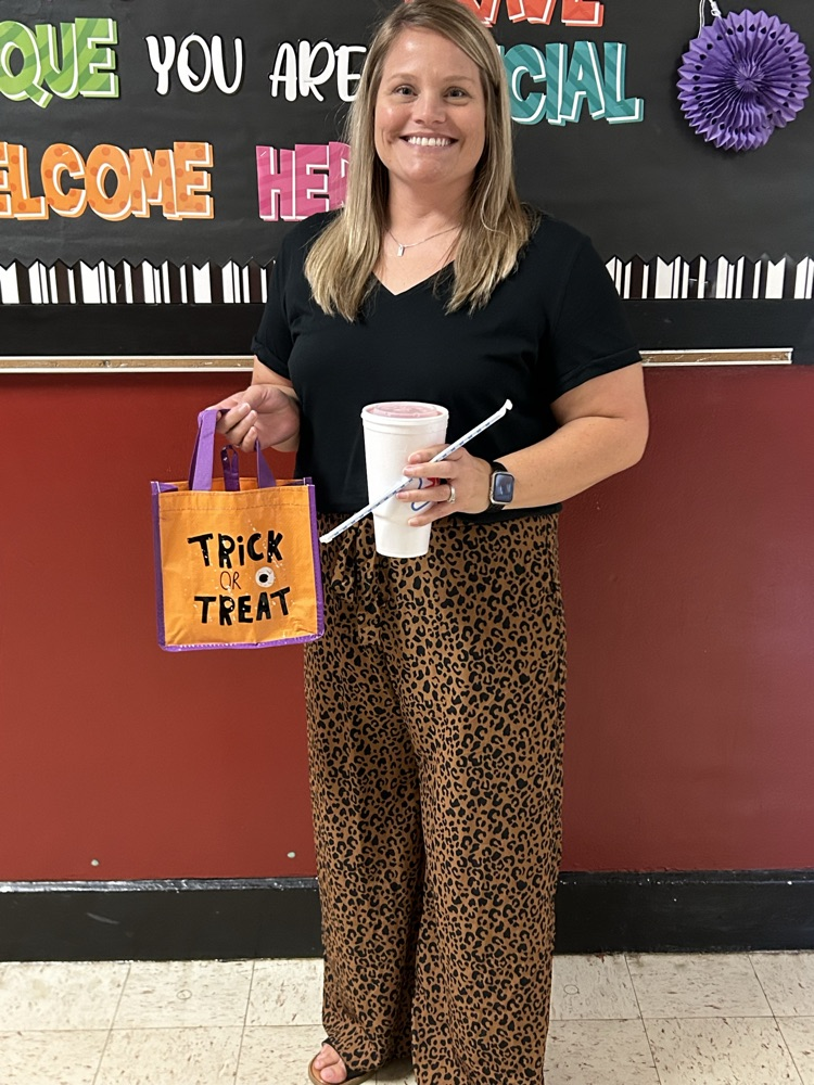 Staff member smiling with sonic drink and trick-or-treat bag