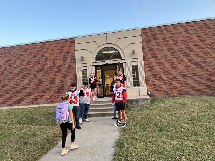 football players greeting students