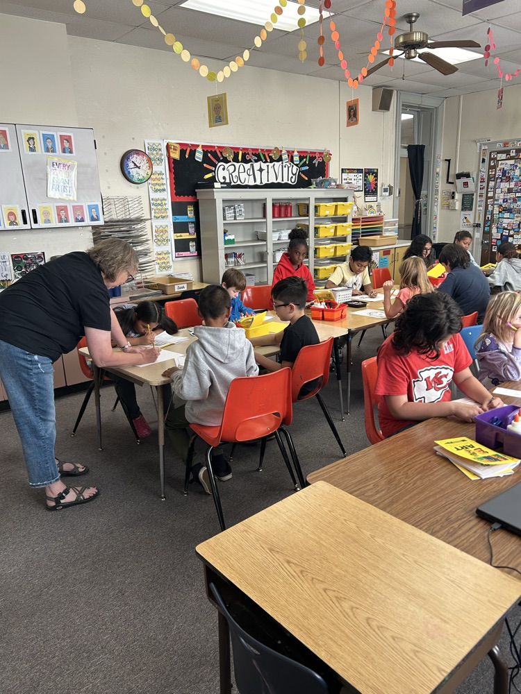 teacher helping students at table