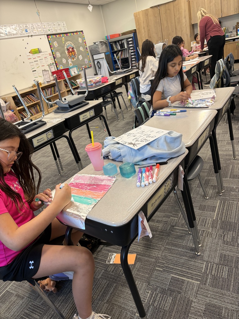 2 girls coloring with group in the background