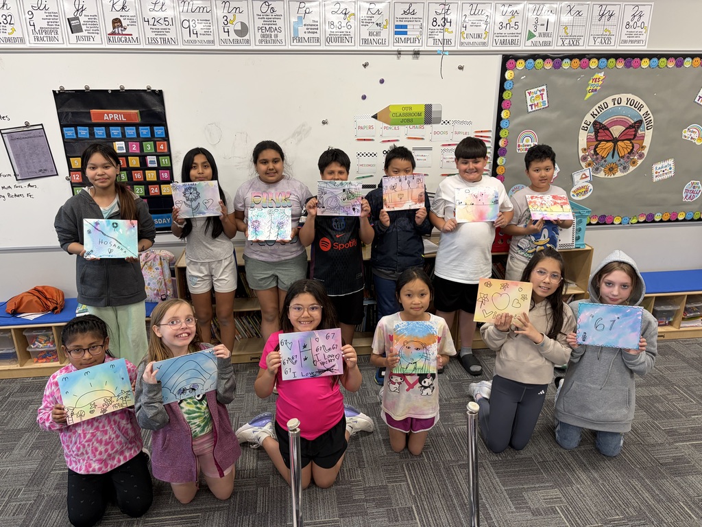 group of kids holding up art projects