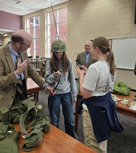 Group of people looking and trying on army uniform