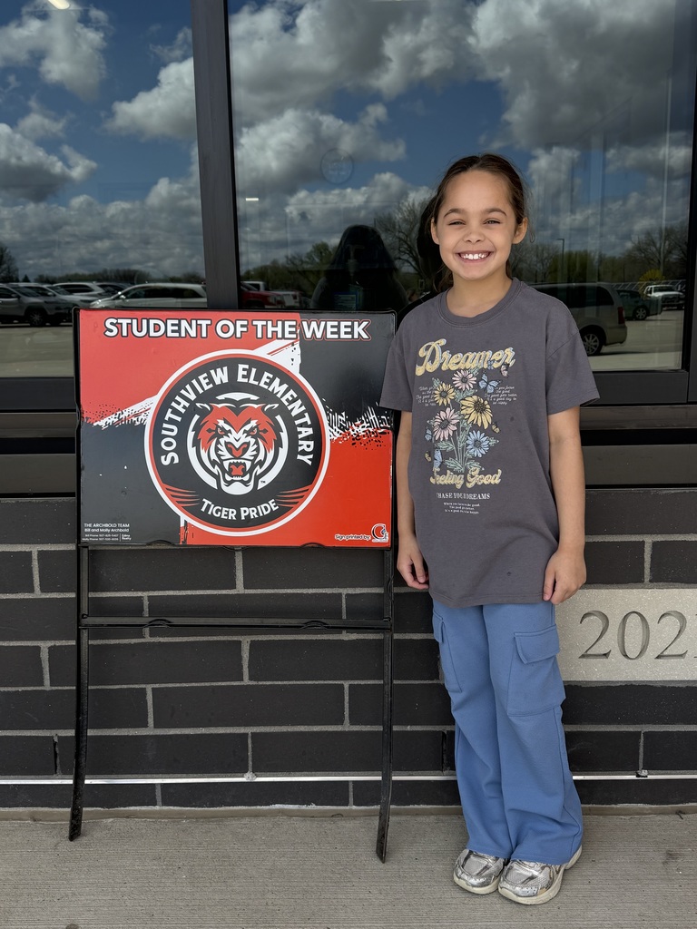Little girl standing next to Tiger Student of the Week Sign