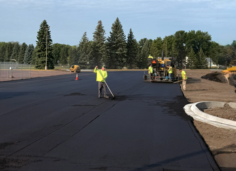 Construction crew laying asphalt