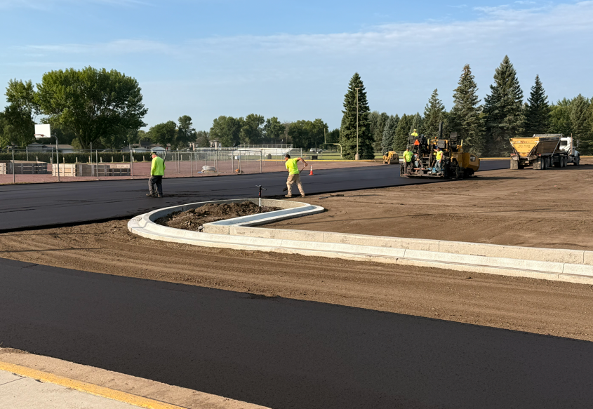 Construction crew laying asphalt