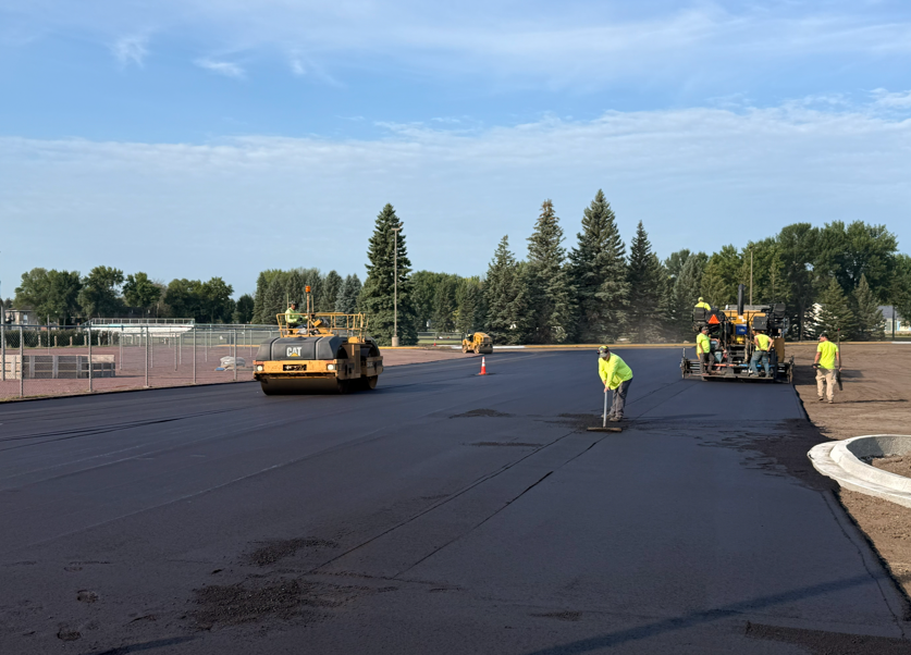 Construction crew laying asphalt