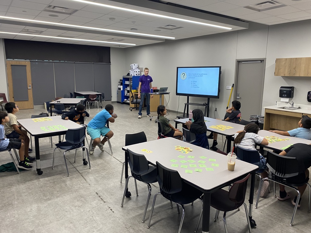 group of kids sitting at tables with instructor in the front of the class
