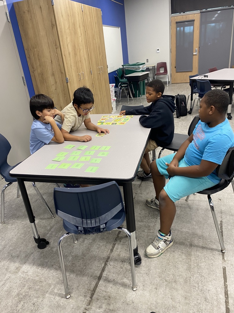 group of kids sitting at tables with instructor in the front of the class