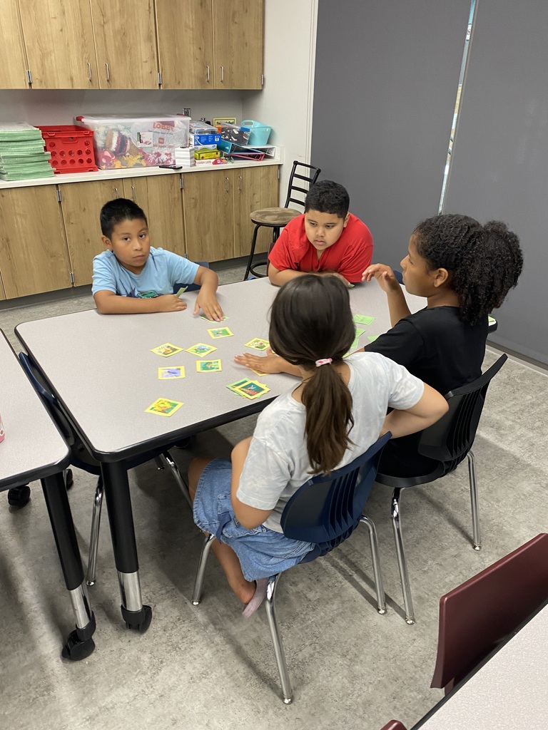 group of kids sitting at tables with instructor in the front of the class