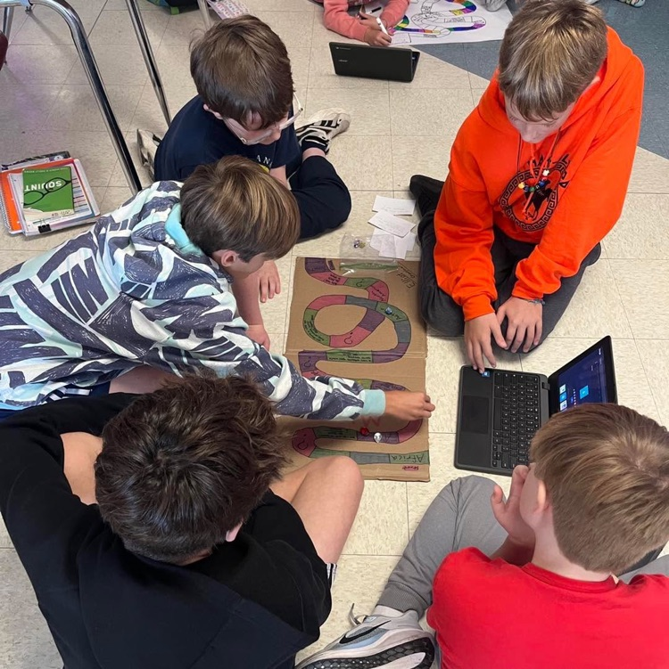 students creating and playing a board game