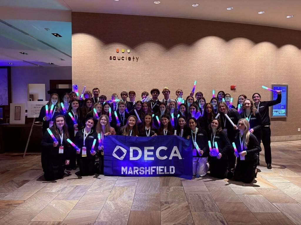 Group of students with DECA Marshfield banner