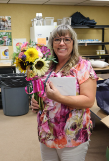 Woman holding up flowers and card