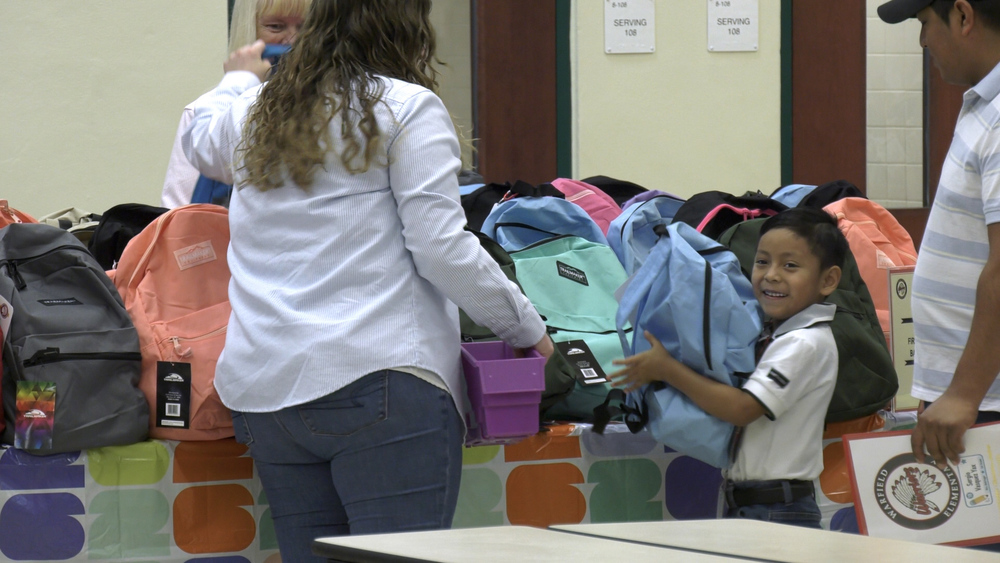 Warfield Elementary School student picks out his new light blue backpack during the school's Meet the Teacher event