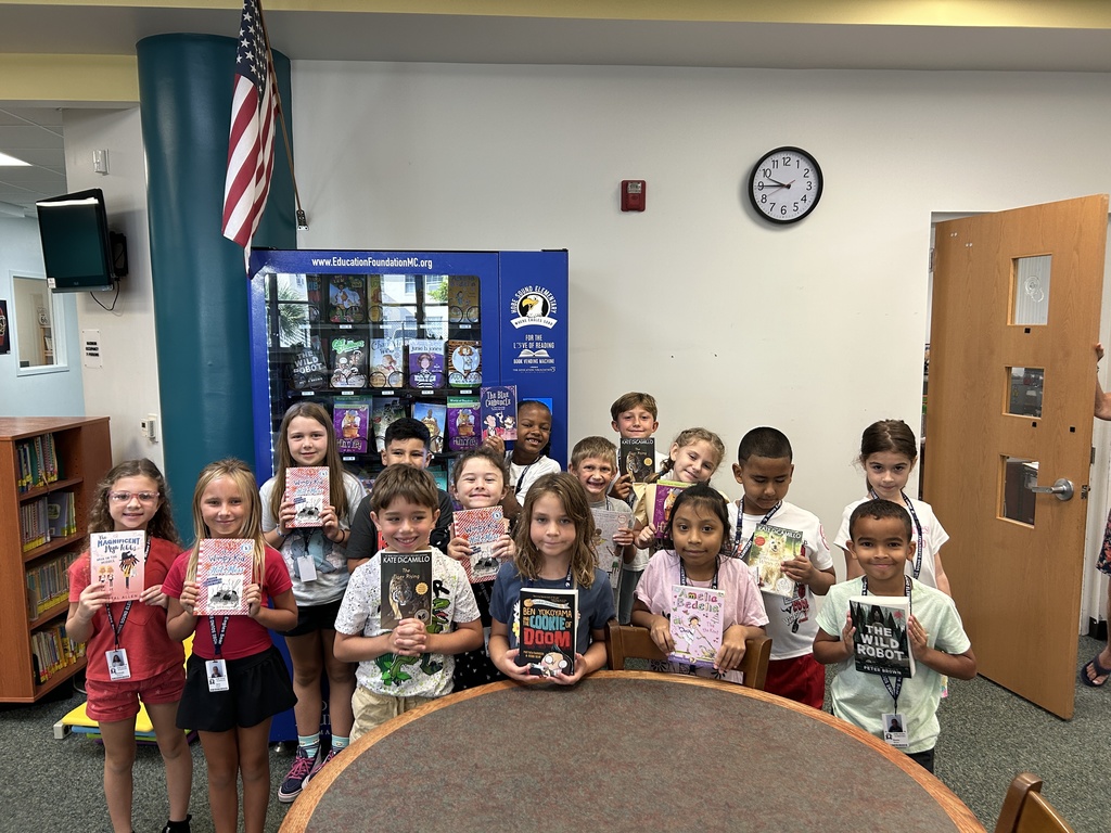 Second grade class holding books.