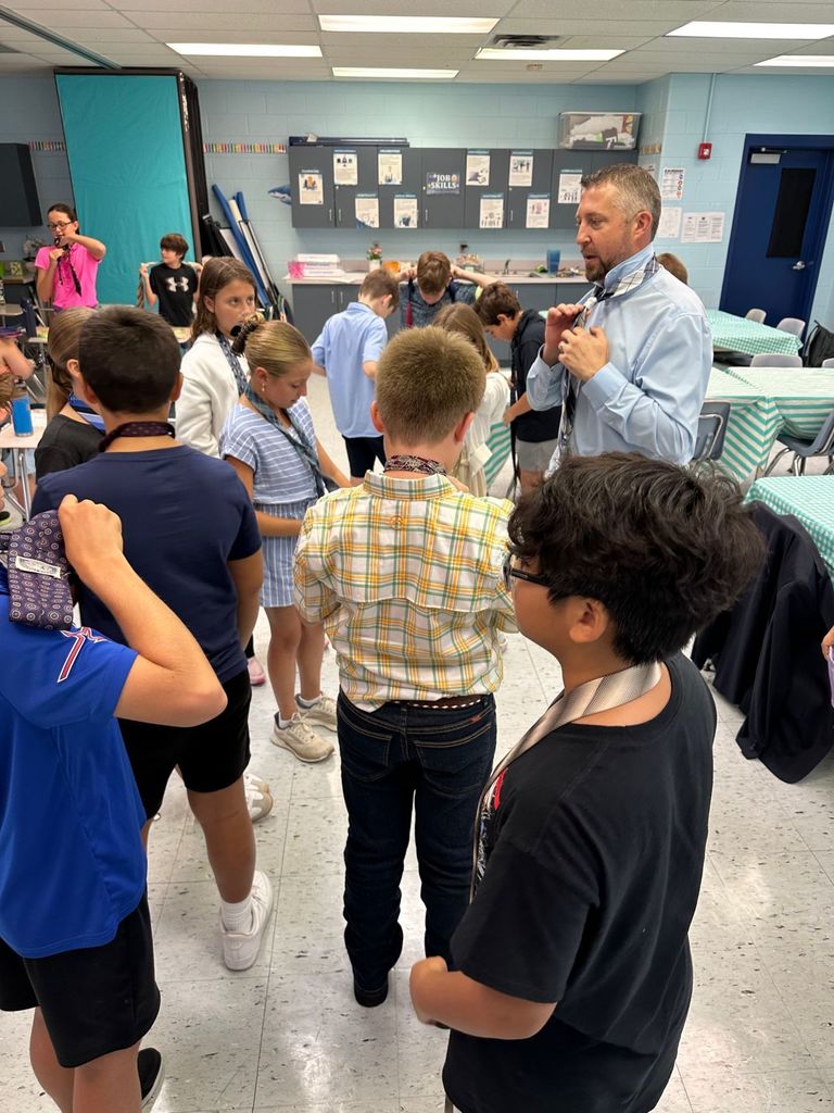 HOMS Principal teaches students how to tie a tie for AVID