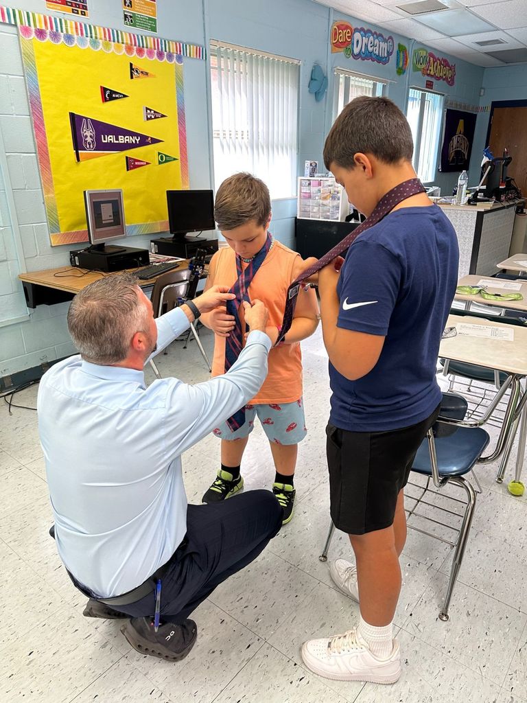 HOMS Principal teaches students how to tie a tie for AVID