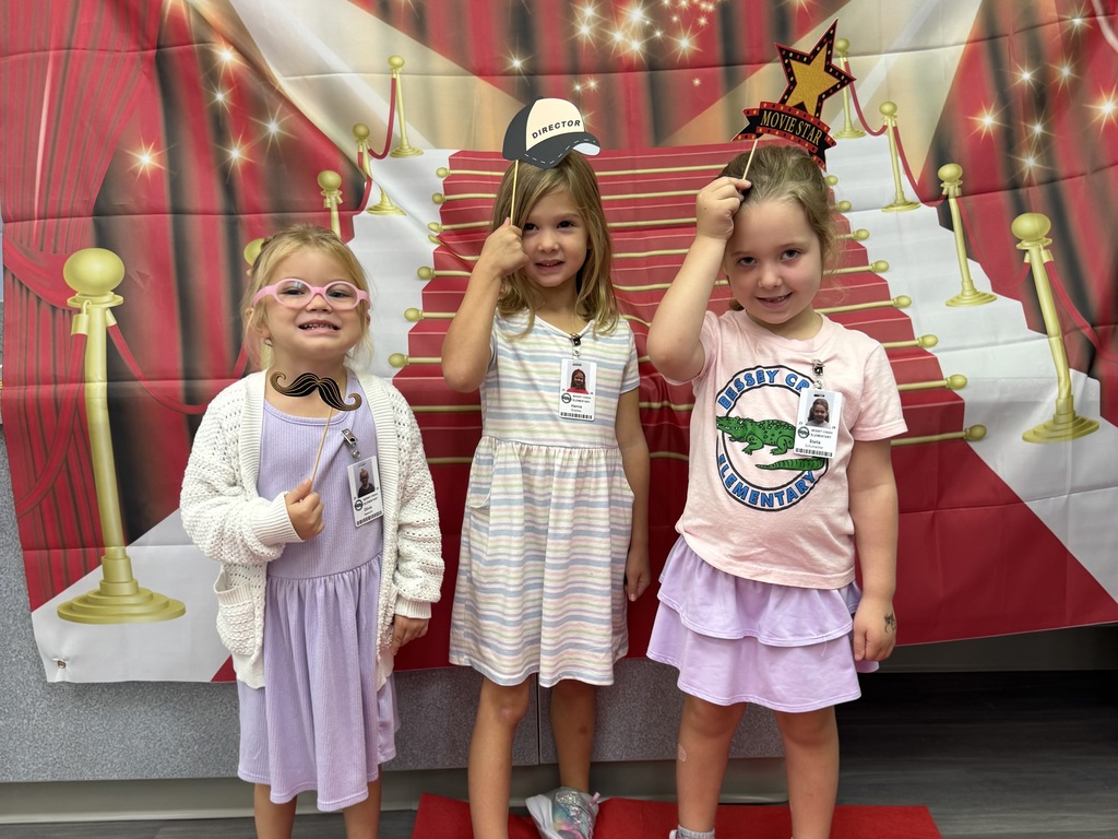 S.T.A.R. Gator Students pose in a room with a red carpet backdrop.