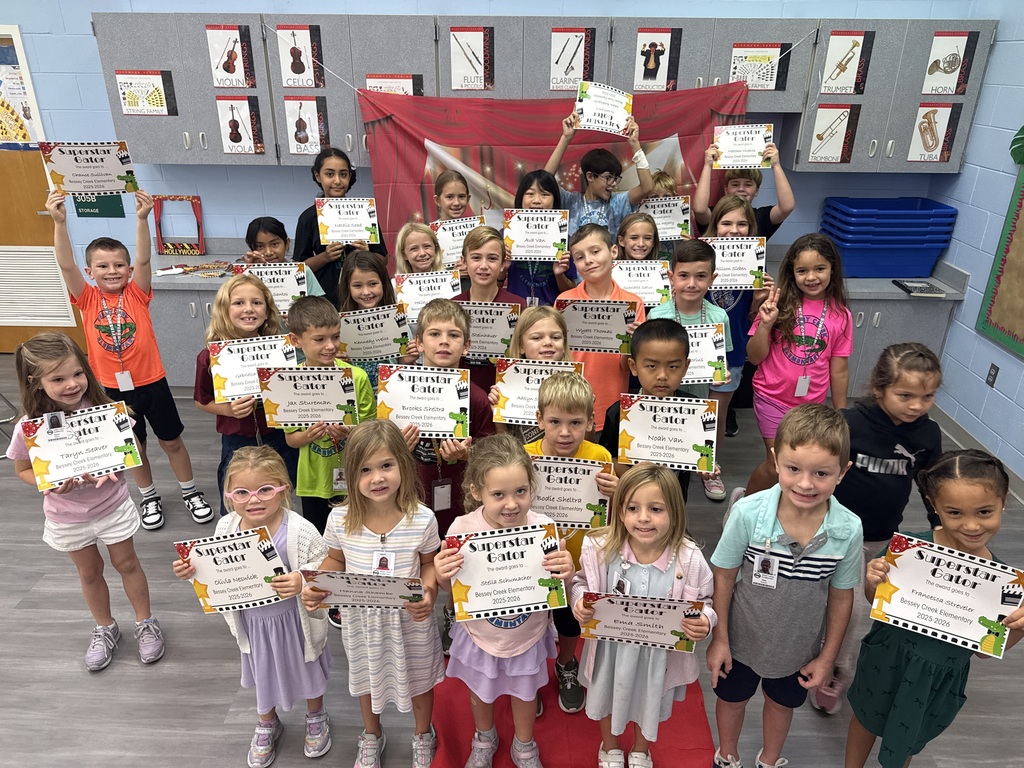 S.T.A.R. Gator Students pose in a room with a red carpet backdrop.
