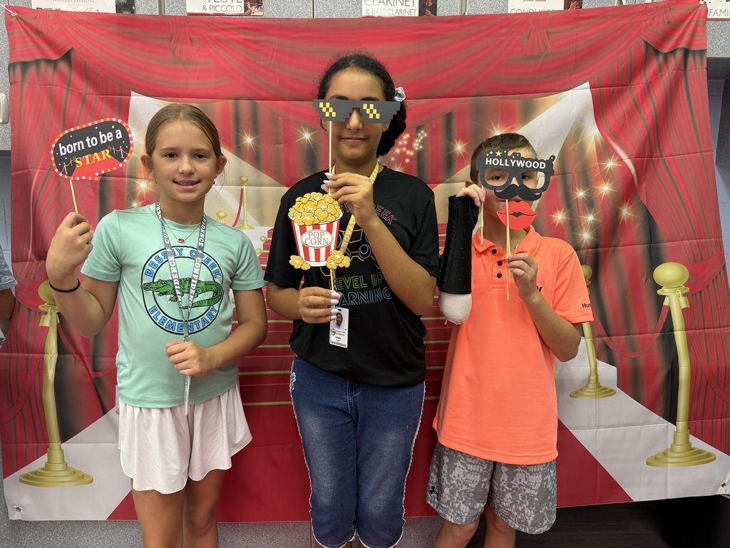 S.T.A.R. Gator Students pose in a room with a red carpet backdrop.