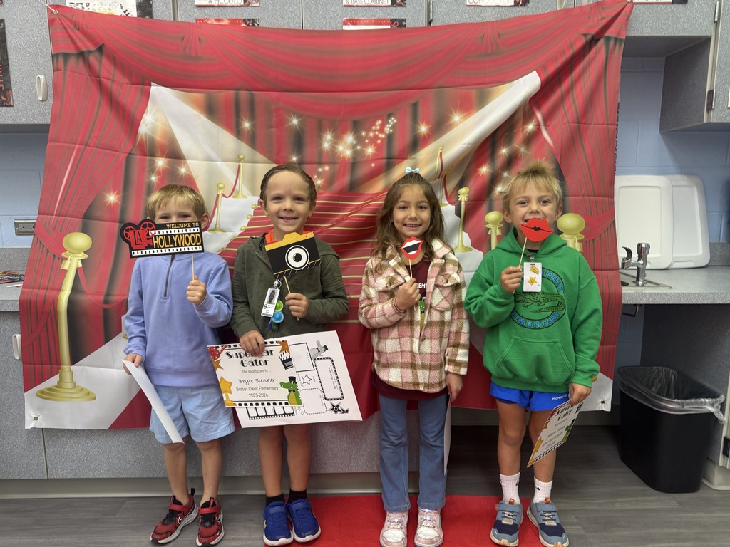 S.T.A.R. Gator Students pose in a room with a red carpet backdrop.