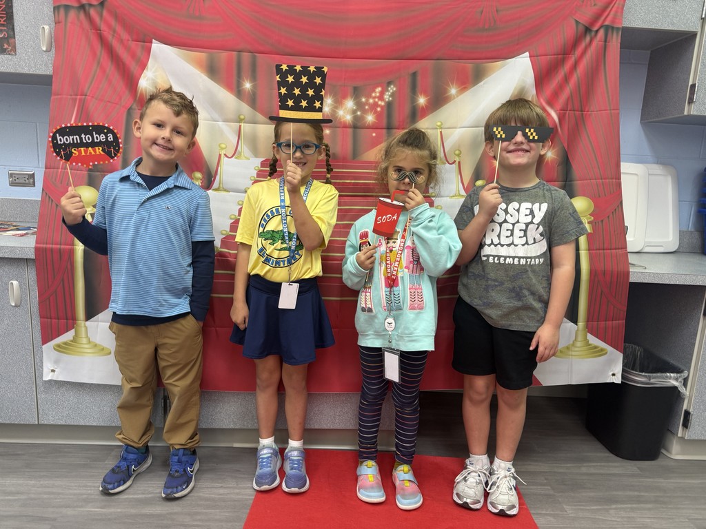 S.T.A.R. Gator Students pose in a room with a red carpet backdrop.