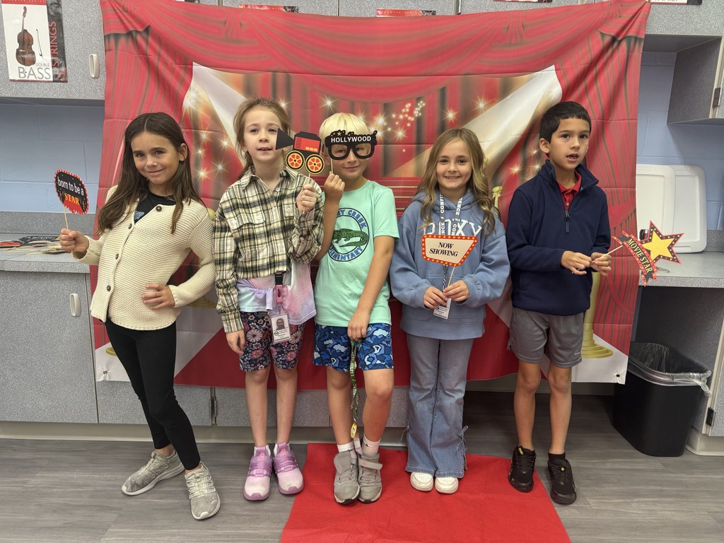S.T.A.R. Gator Students pose in a room with a red carpet backdrop.