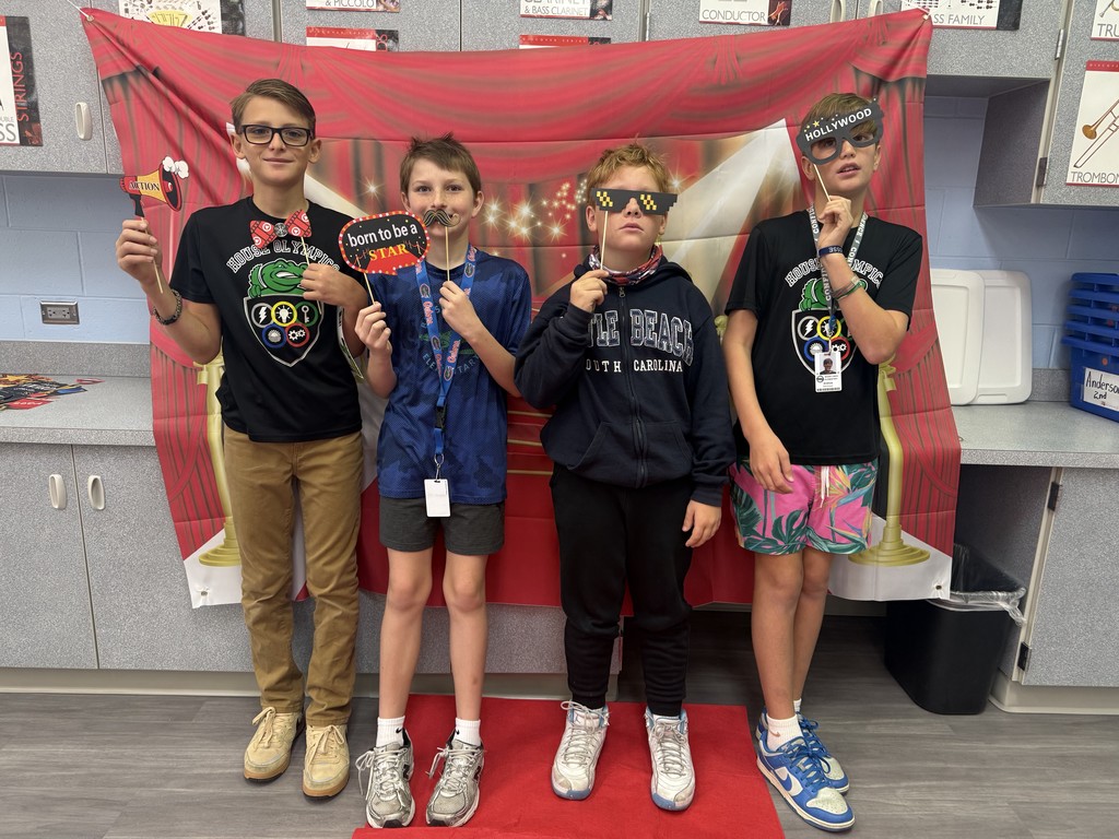 S.T.A.R. Gator Students pose in a room with a red carpet backdrop.